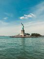The Statue of Liberty stands tall in New York Harbor on Liberty Island, ready to welcome immigrants arriving by sea.